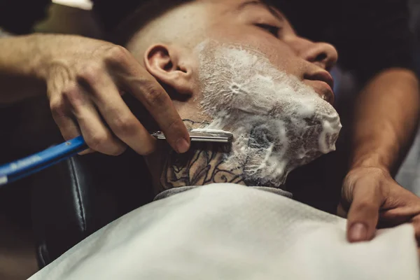 Anonymous man shaving client — Stock Photo, Image