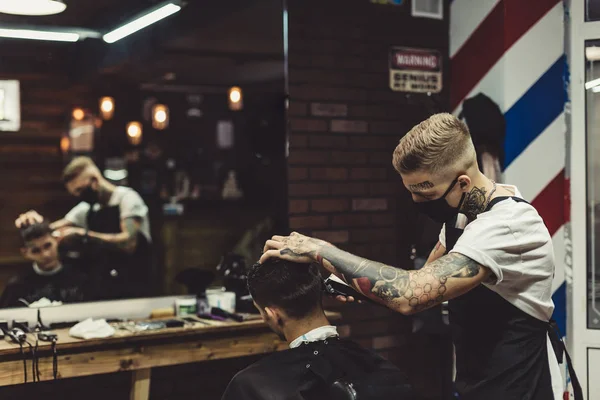 Barber shaving man in chair