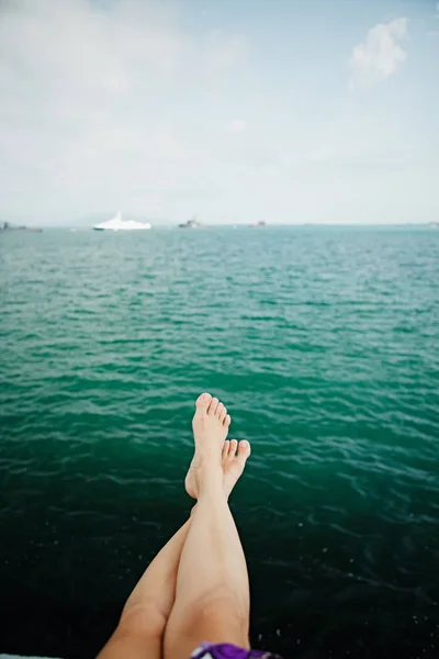 Ernte weibliche Füße über dem Meerwasser — Stockfoto