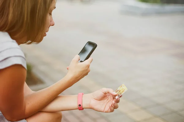 Женщина, использующая телефон и карту для покупок — стоковое фото