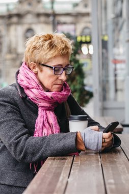 Kadın Smartphone dış kafede tarama