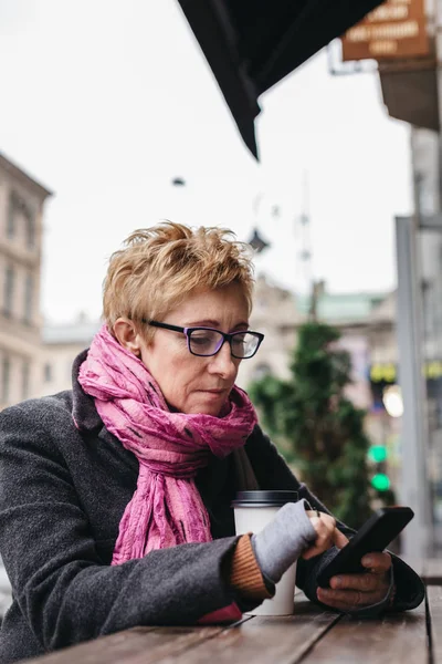 Mujer navegando teléfono inteligente en la cafetería exterior — Foto de Stock