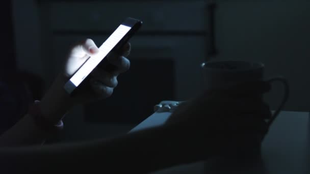 Woman uses a smart phone in a dark room — Stock Video