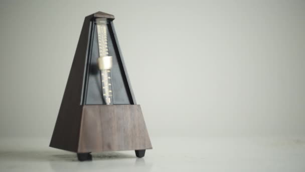 Vintage metronome med gyllene pendeln slår långsam rytm — Stockvideo