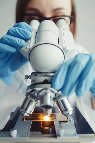 Close up of examining of test sample under the microscope — Stock Photo, Image