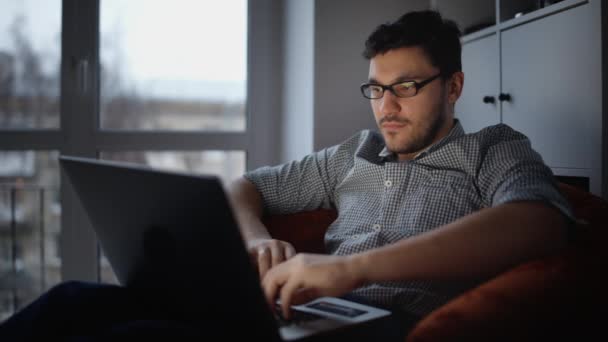 Junger Mann sitzt mit Laptop — Stockvideo