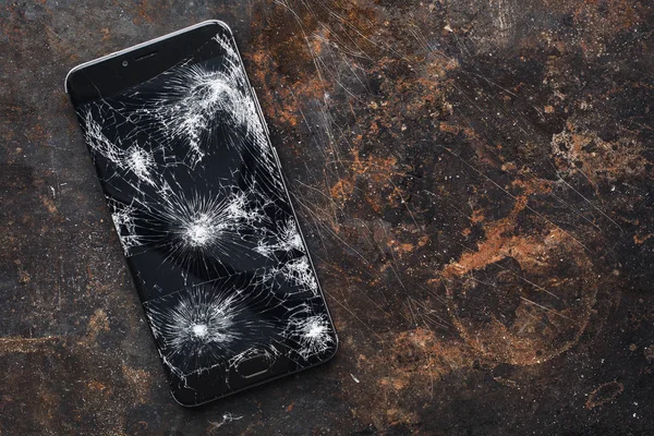 Big modern smartphone with broken screen debris
