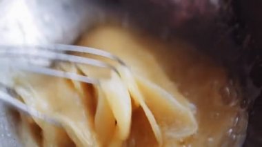 Chef malzemeler hamur için bir çırpma teli ile karıştırın