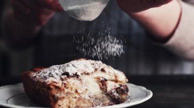Eller üzerinde parça pasta pudra şekeri ekleyerek Cook