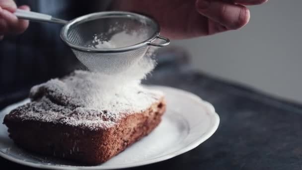 Manos de cocinero añadiendo azúcar en polvo en el pastel de peice — Vídeos de Stock