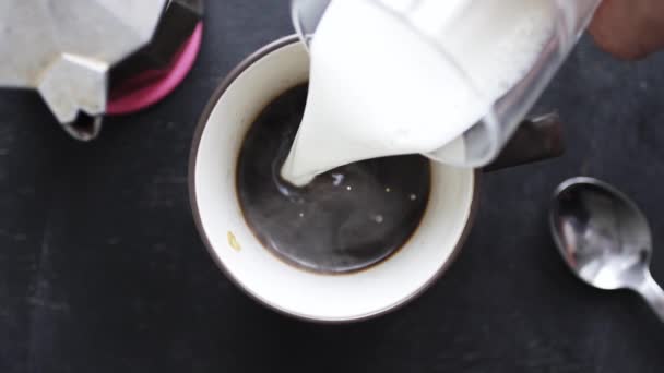 Milch wird in Kaffee gegossen — Stockvideo
