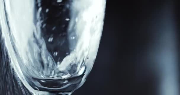 Vasos con burbujas de champán sobre fondo oscuro — Vídeo de stock