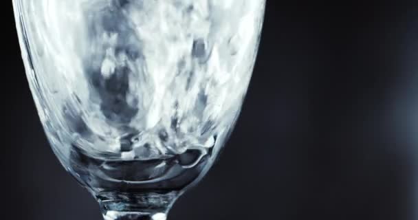 Glasses with champagne bubbles on dark background — Stock Video