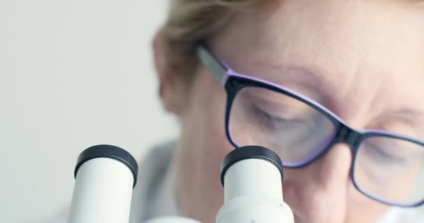 Cientista feminina olhando através do microscópio — Vídeo de Stock