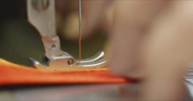 Endüstriyel dikiş makinesinde çalışan kadın terzi..