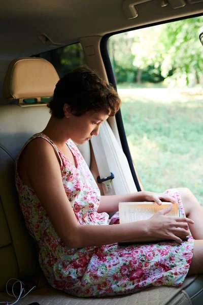 Девочка читает книгу в машине в поездке — стоковое фото