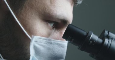 Mikroskoba bakan erkek bilim adamı