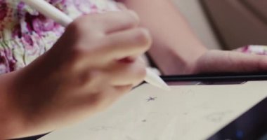 Kulaklıklı yaratıcı kız araba camına bakıyor ve yol boyunca tablet çiziyor.