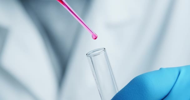 Technician carefully drips the solution from the pipette into glass tubes. — Stock Video