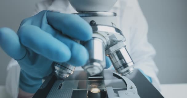 Detailní záběr vědeckých studií zkoumajících testovací vzorek pod mikroskopem. — Stock video