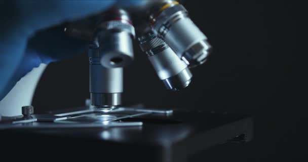 Primer plano de cultivo de microscopio en el laboratorio, científico está llevando a cabo el estudio examina — Vídeo de stock