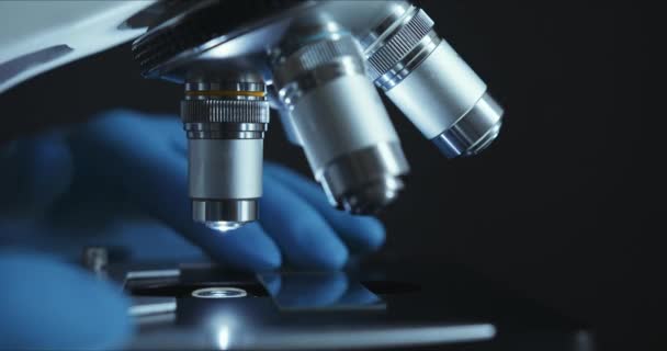 Обрезание крупным планом микроскопа в лаборатории, ученый проводит исследования — стоковое видео
