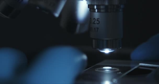 Обрезание крупным планом микроскопа в лаборатории, ученый проводит исследования — стоковое видео