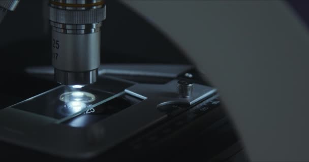 Crop closeup shot of microscope in the laboratory, scientist is conducting study examines — Stock Video