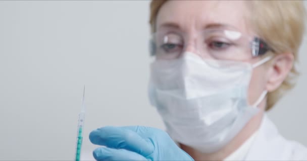 Doctor in front of the camera preparing syringe with avaccine for injection — Αρχείο Βίντεο