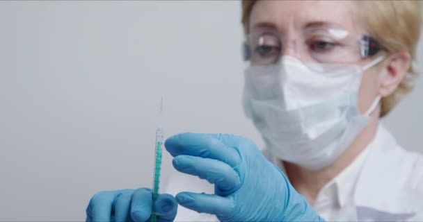 Médico à frente da câmara a preparar a seringa com a vacina injectável — Vídeo de Stock