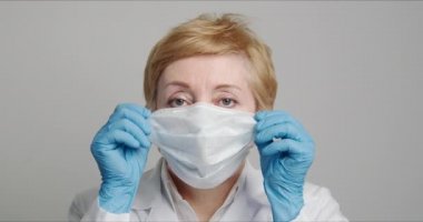 Yetişkin kadın doktor tıbbi bir maske takar.