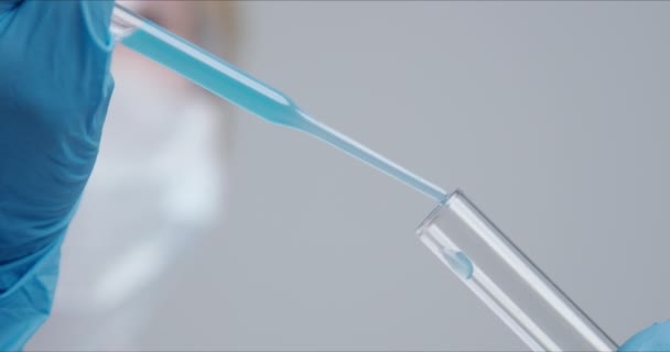 Технік ретельно вводить розчин з піпетки в скляні труби . — стокове відео