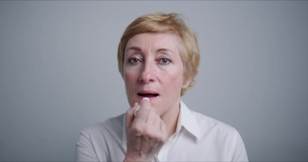 Erwachsene Frauen. Sie bemalt ihre Lippen mit Lippenstift — Stockvideo