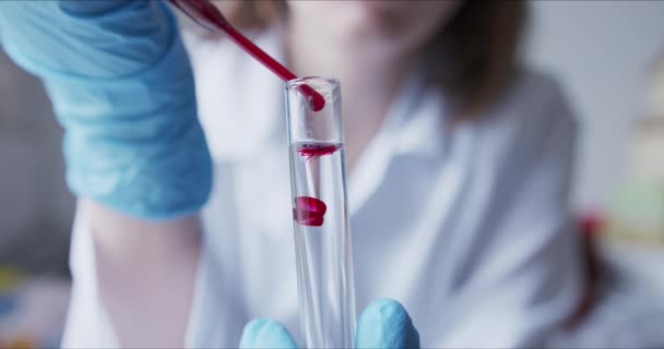 Scientifique avec pipette analyse liquide de couleur rouge pour extraire l'ADN — Video