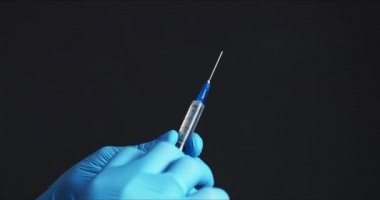 Doktor iğneye aşı hazırlıyor.