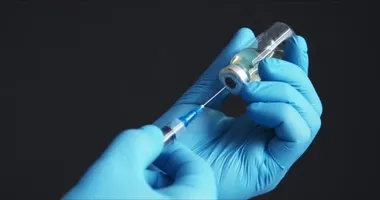 Doktor iğneye aşı hazırlıyor.