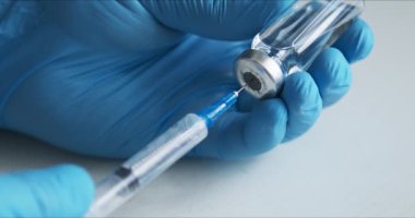 Doktor iğneye aşı hazırlıyor.