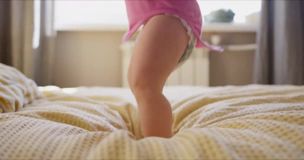 Bebé niña saltar en sus padres cama — Vídeo de stock