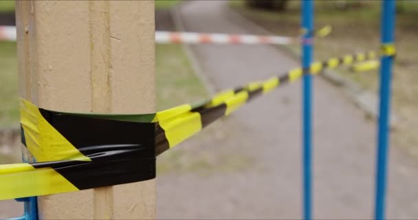 Zona de juegos cerrada con cinta de rayas para cuarentena durante la epidemia — Vídeo de stock