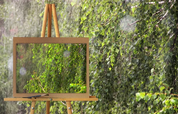 Easel with a painting watercolor illustration rainy day. Pine an