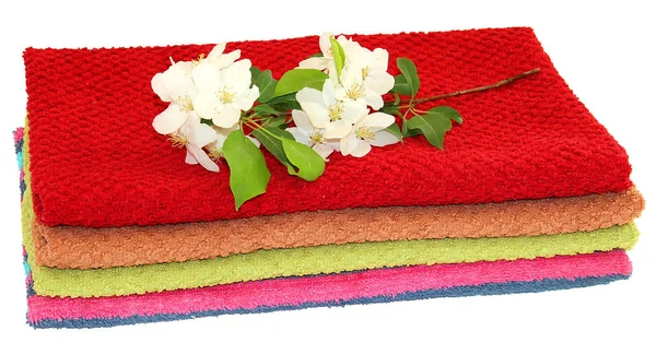 Ramo con fiori bianchi su un mucchio di asciugamani di spugna — Foto Stock