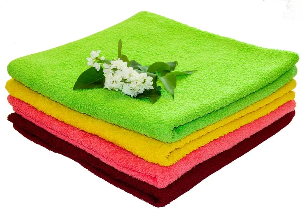 Ramo con fiori bianchi su un mucchio di asciugamani di spugna — Foto Stock