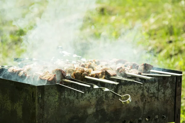 Barbecue sur le gril en été à l'extérieur, les mains tournent le robinet — Photo