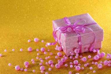 Sarı zemin üzerine hediye ile pembe kutu