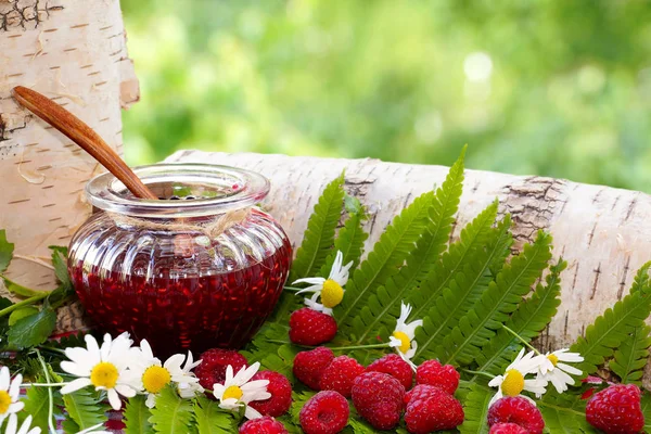 Ahududu. Açık bir kavanoz reçel ve ahududu orman otlar arasında.