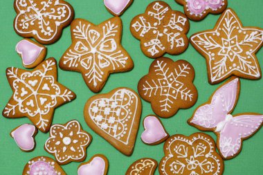 Yeşil bir arka plan üzerine ev yapımı zencefilli kurabiye. Yukarıdan görüntüleyin. Evde pişmiş yılbaşı tatlılar