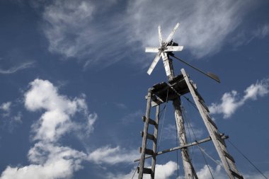 Mavi gökyüzü ve bulutların arka planında rüzgar jeneratörü