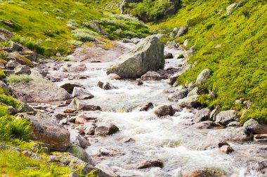 Güzel görünüm karşı bir çözülme buzul kaynaklanan odunsu dağlar road yakınındaki dağ Nehri üzerinde. başında ünlü Şelalesi Langfossen, Norveç.
