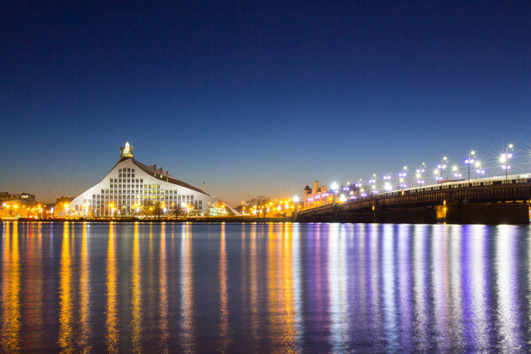 Beautiful night view to Latvian national library and stone bridge over Daugava river in Riga Latvia. Night, Xmas illuminated scene.