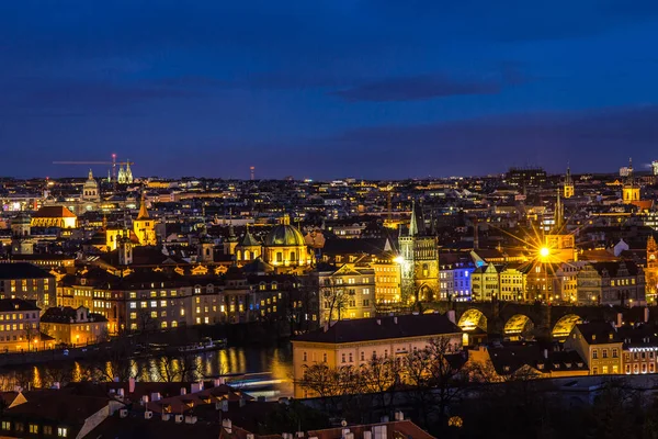 Hermosa vista nocturna sobre el río Moldava, el puente de Carlos, el terraplén de Smetanovo, la torre de la ciudad vieja, la iglesia de San Asís y toda Praga. Destino turístico europeo popular. República de Chech . — Foto de Stock